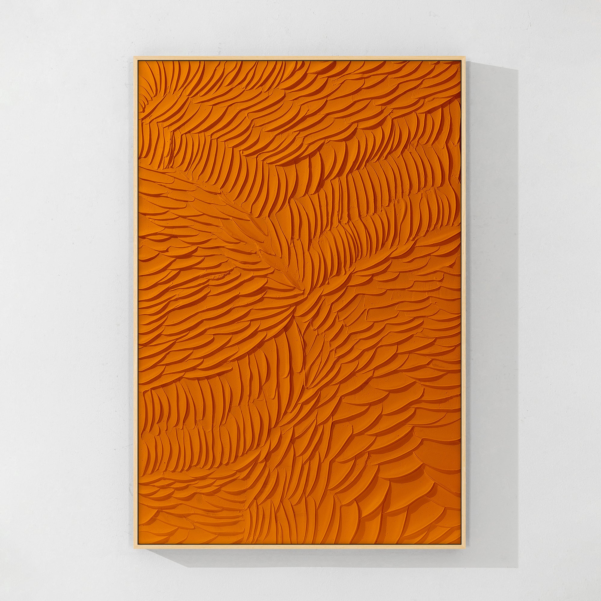 Close-up of 3D orange abstract art with feather details with a wood color frame