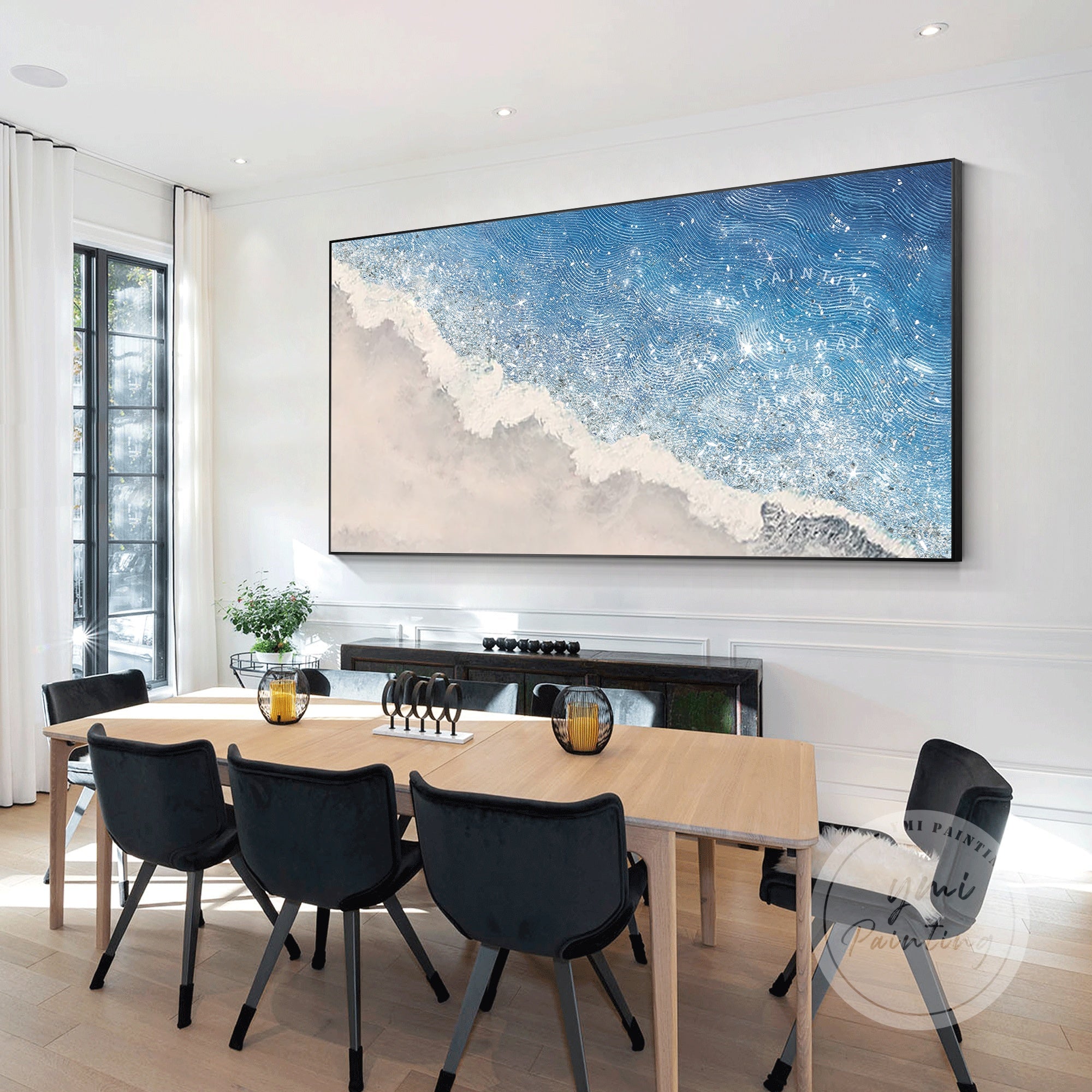 This serene painting blends blue and gray hues with glittering accents, adding elegance to a bedroom.