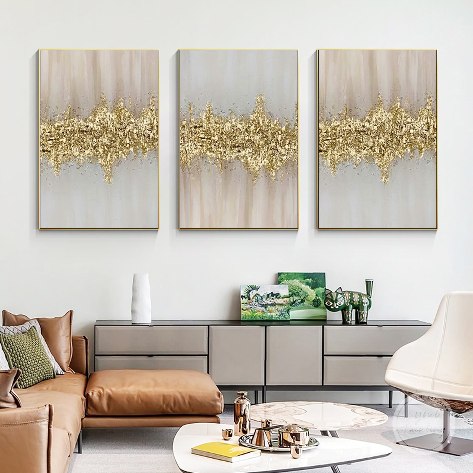Set of three pink and gold textured abstract framed paintings displayed in a modern living room