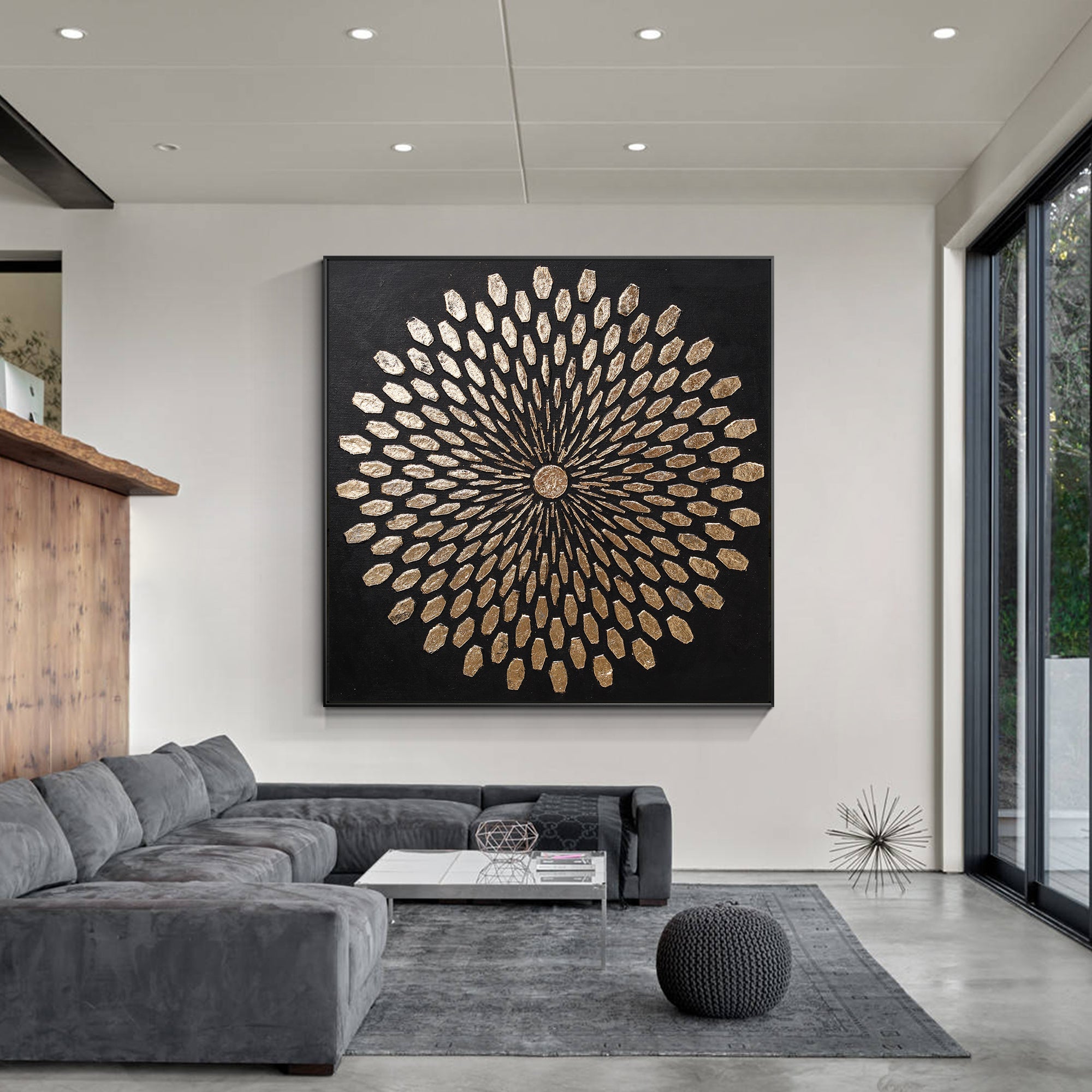 Black and gold abstract painting hanging in a spacious living room