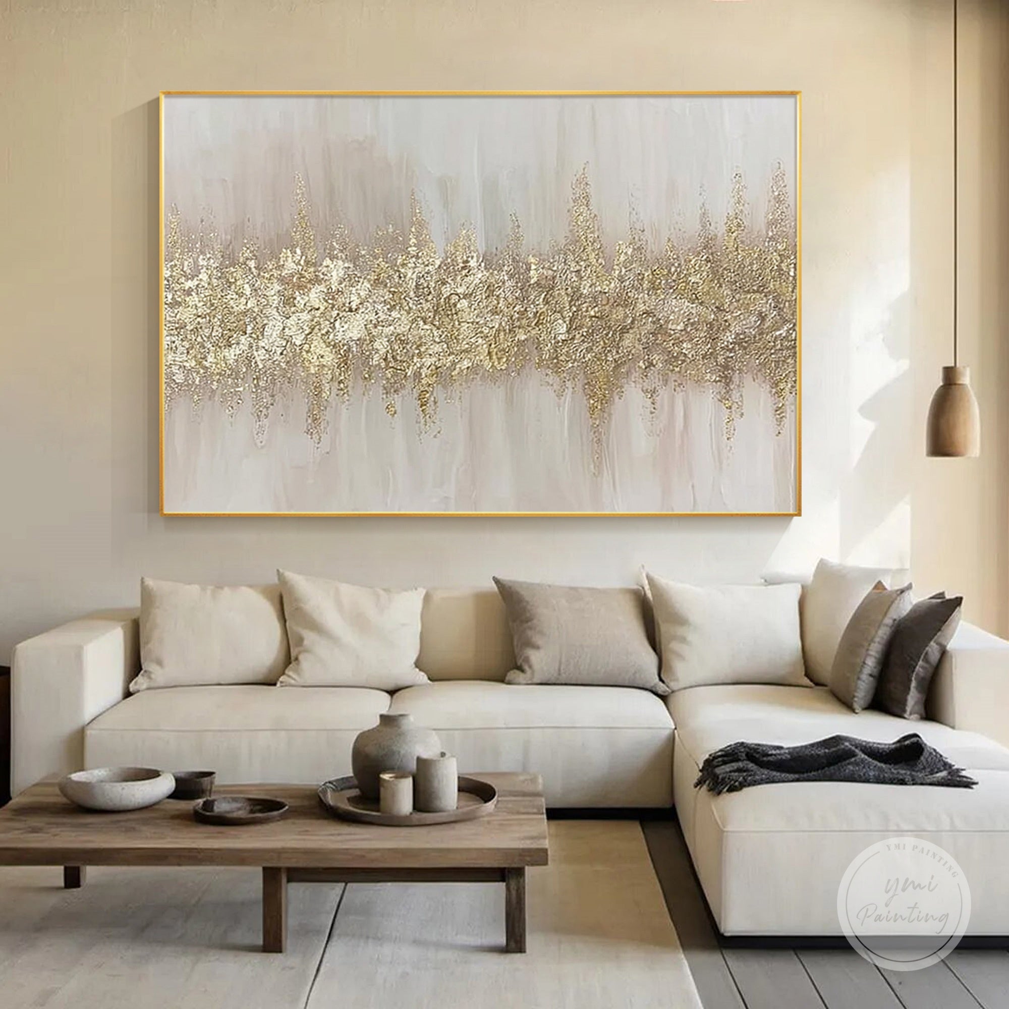Hand painted abstract gold leaf canvas art displayed on a living room wall with neutral tones.