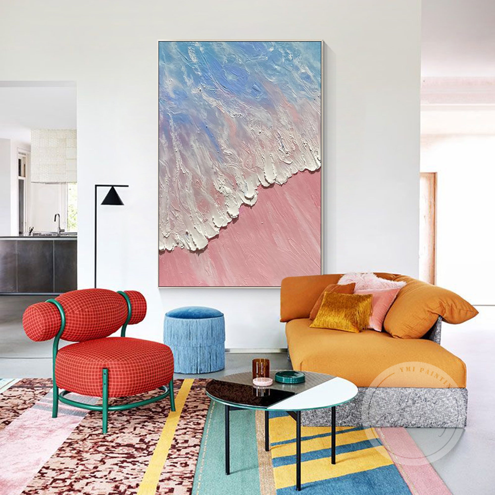 Large framed wall art depicting an abstract coastal landscape with pink sand and blue water.