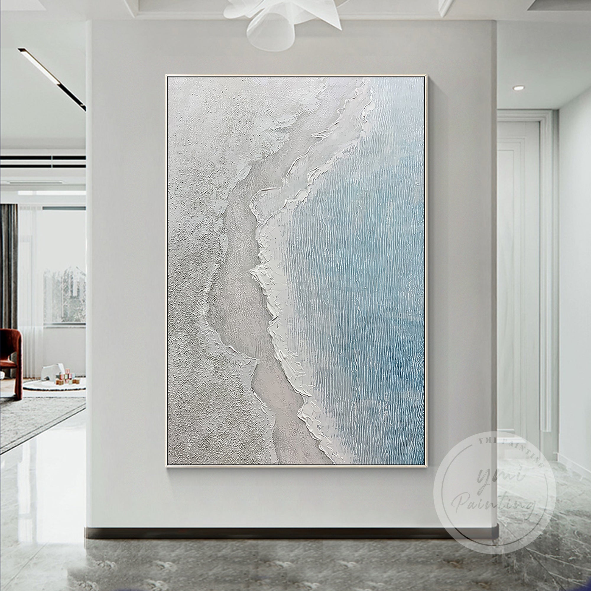 Framed abstract seascape wall art featuring soft white sand and deep blue waters.