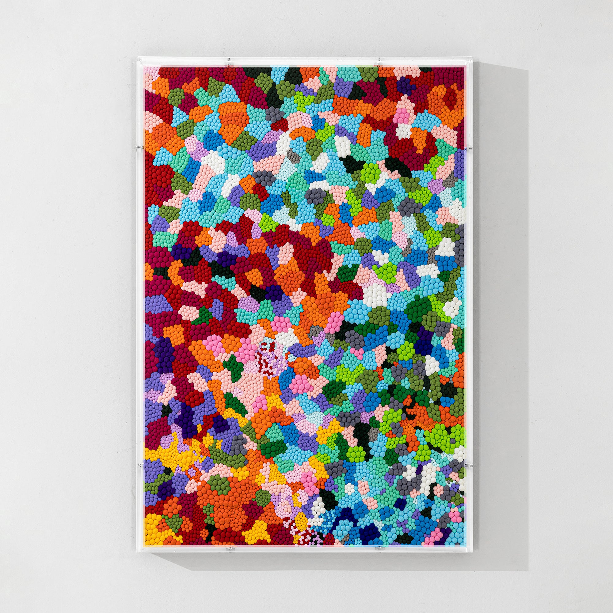 Pom-pom wall decor in bright colors creating a spring park scene above a wooden cabinet