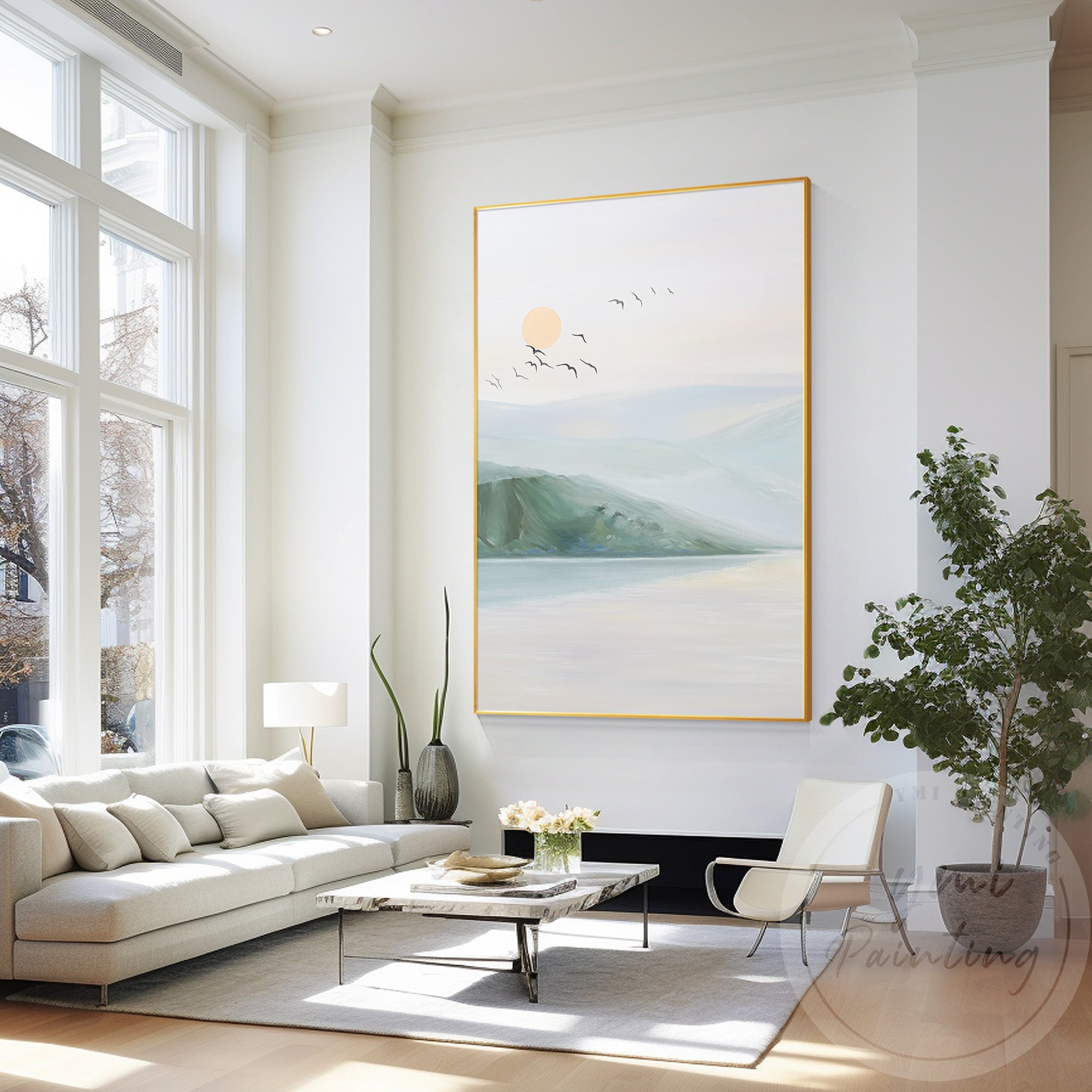 Mountain sunset with reflections in still water and birds flying across a peachy sky.