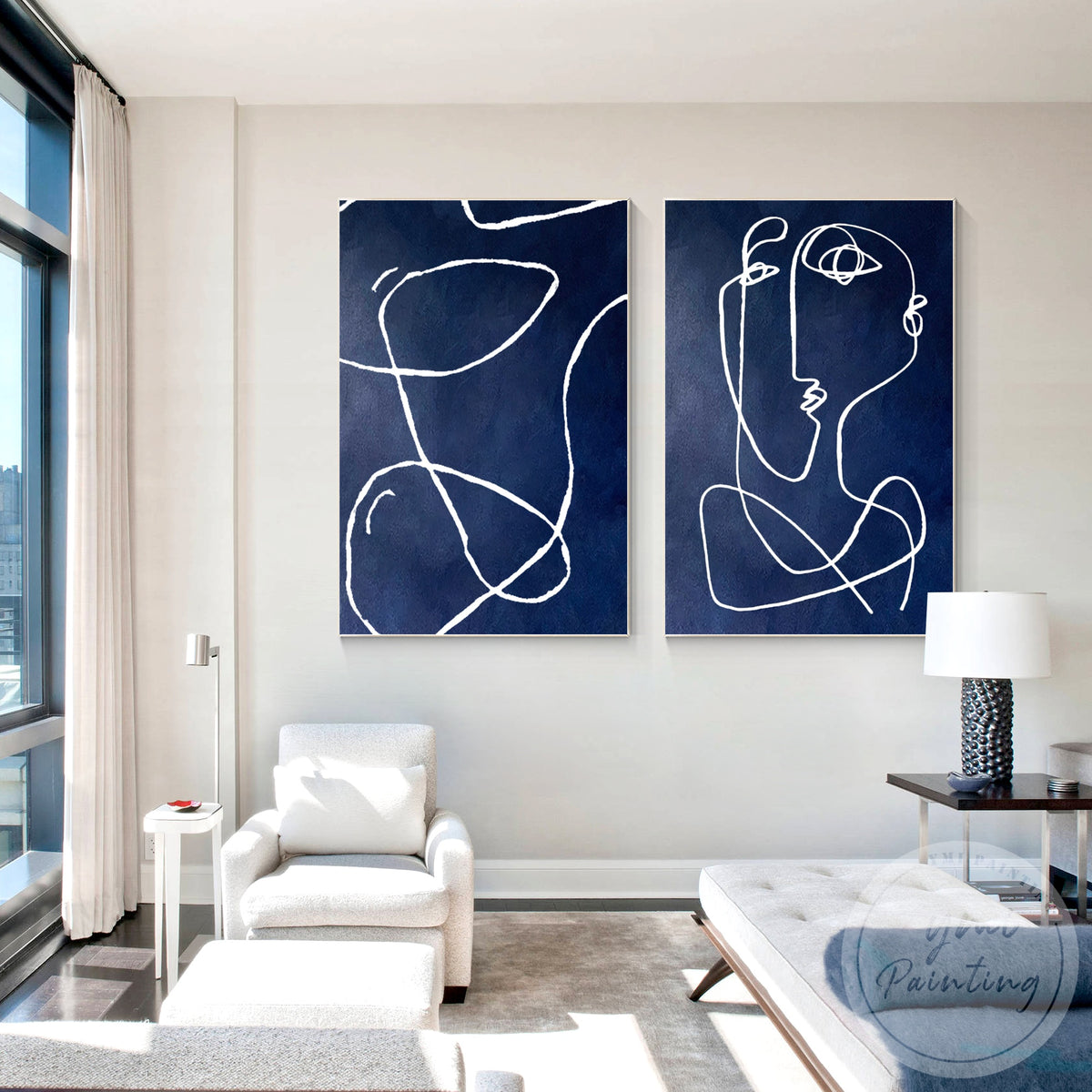 Navy blue abstract painting pair displayed above a modern sofa