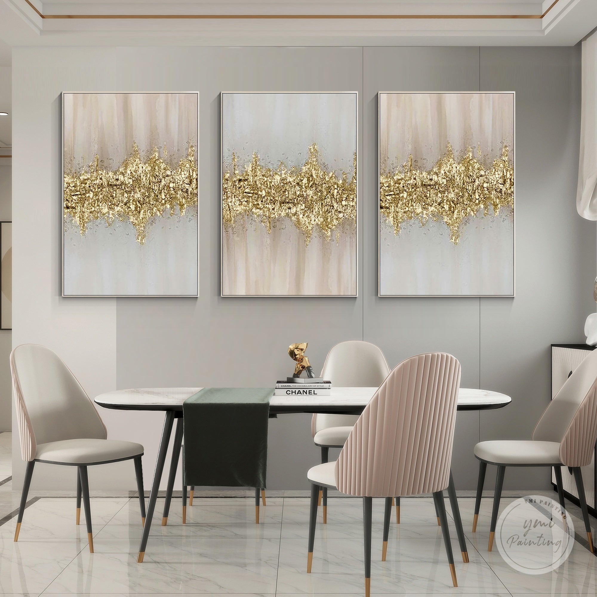 Set of three gold and pink abstract textured framed paintings displayed in a modern dining room