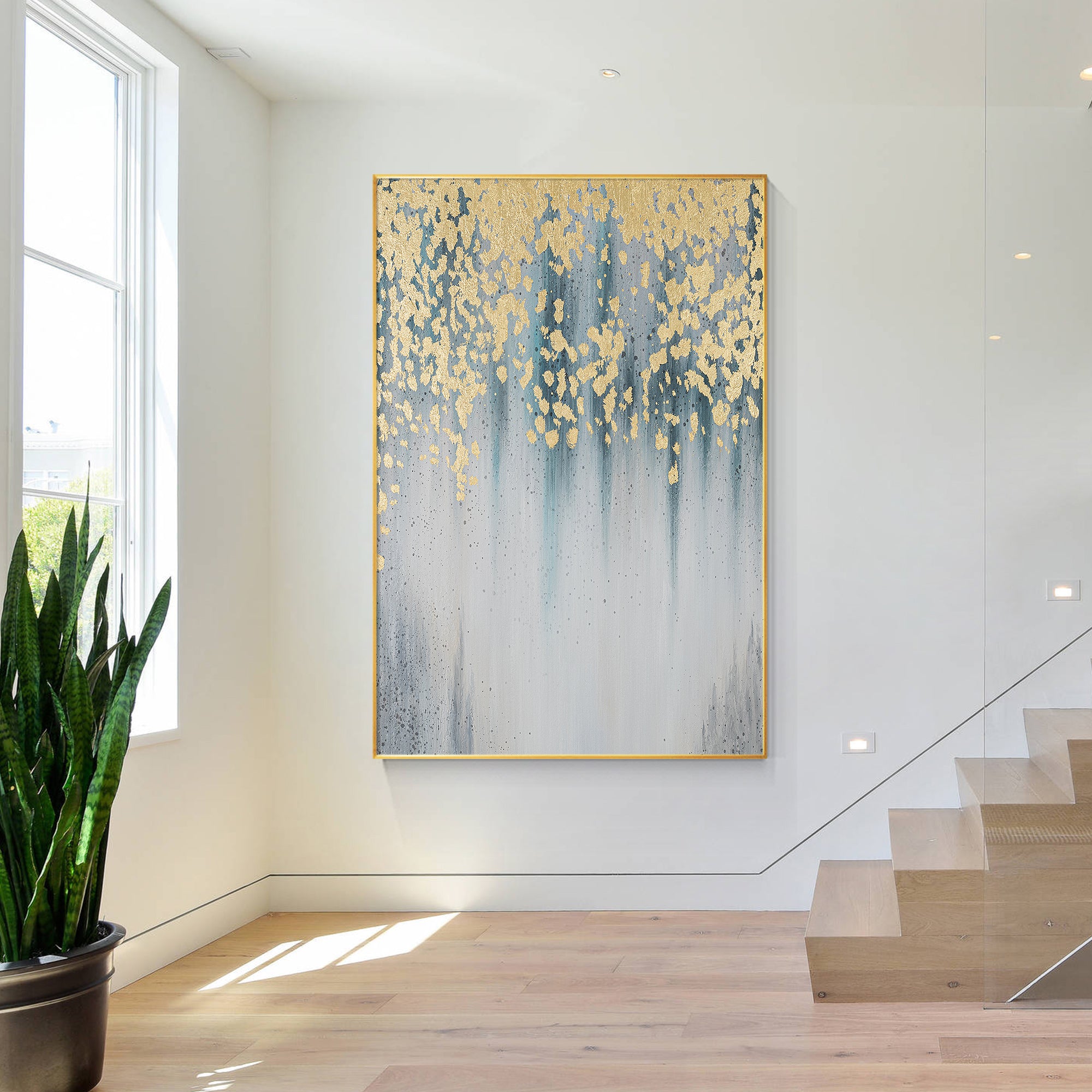 Abstract painting with gold leaf and a serene blue-gray background like water droplets falling on.