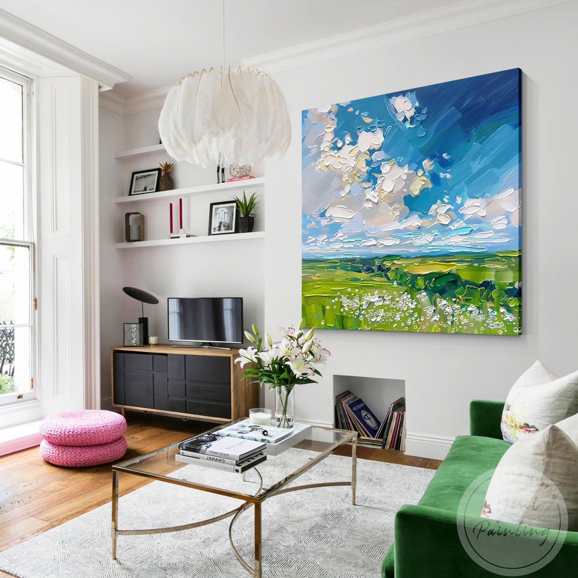 This impressionist-style wall art, depicting lush green fields and soft clouds, creates a warm and inviting atmosphere in any living space.