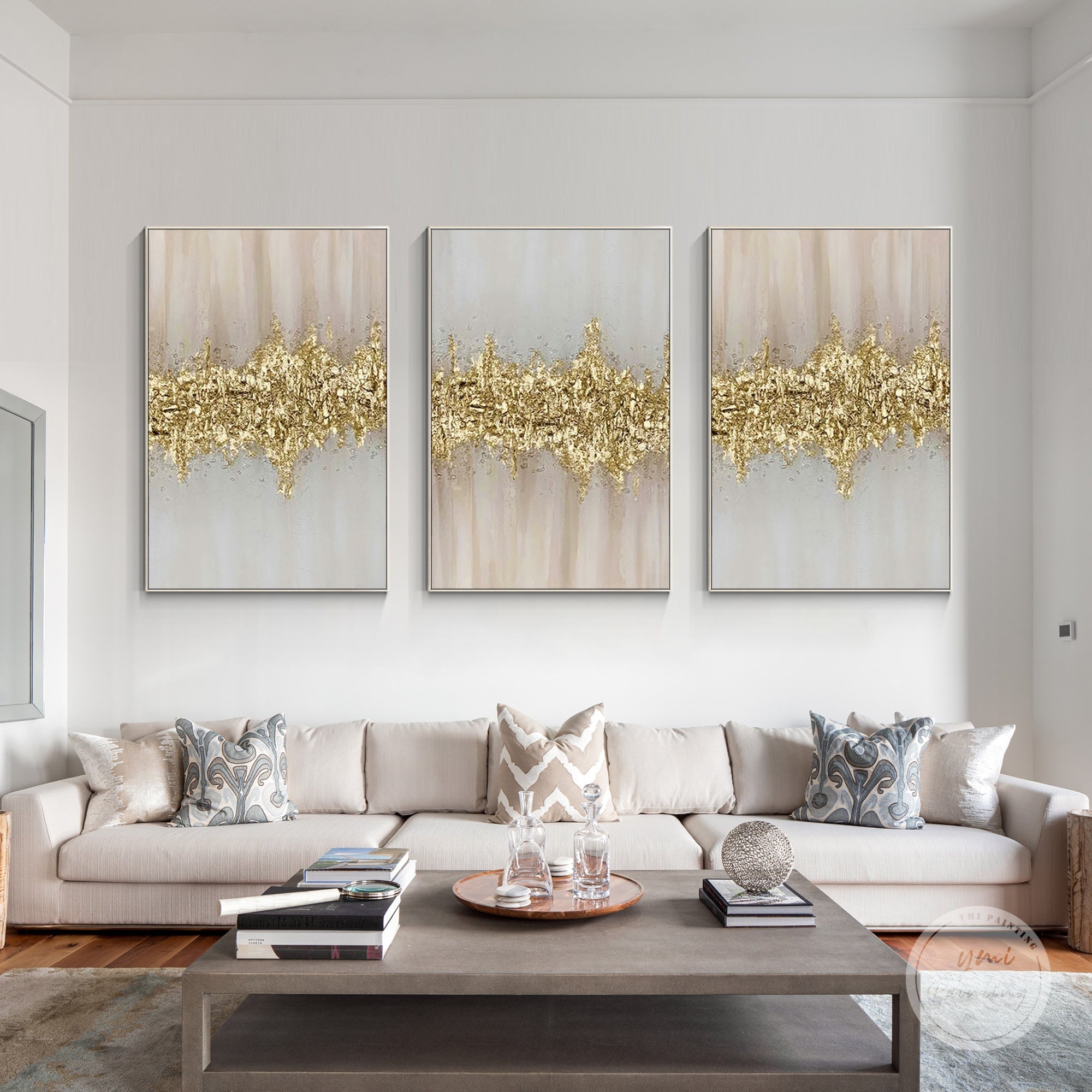 Gold and pink abstract textured painting set of 3 styled above a sofa in a contemporary living room