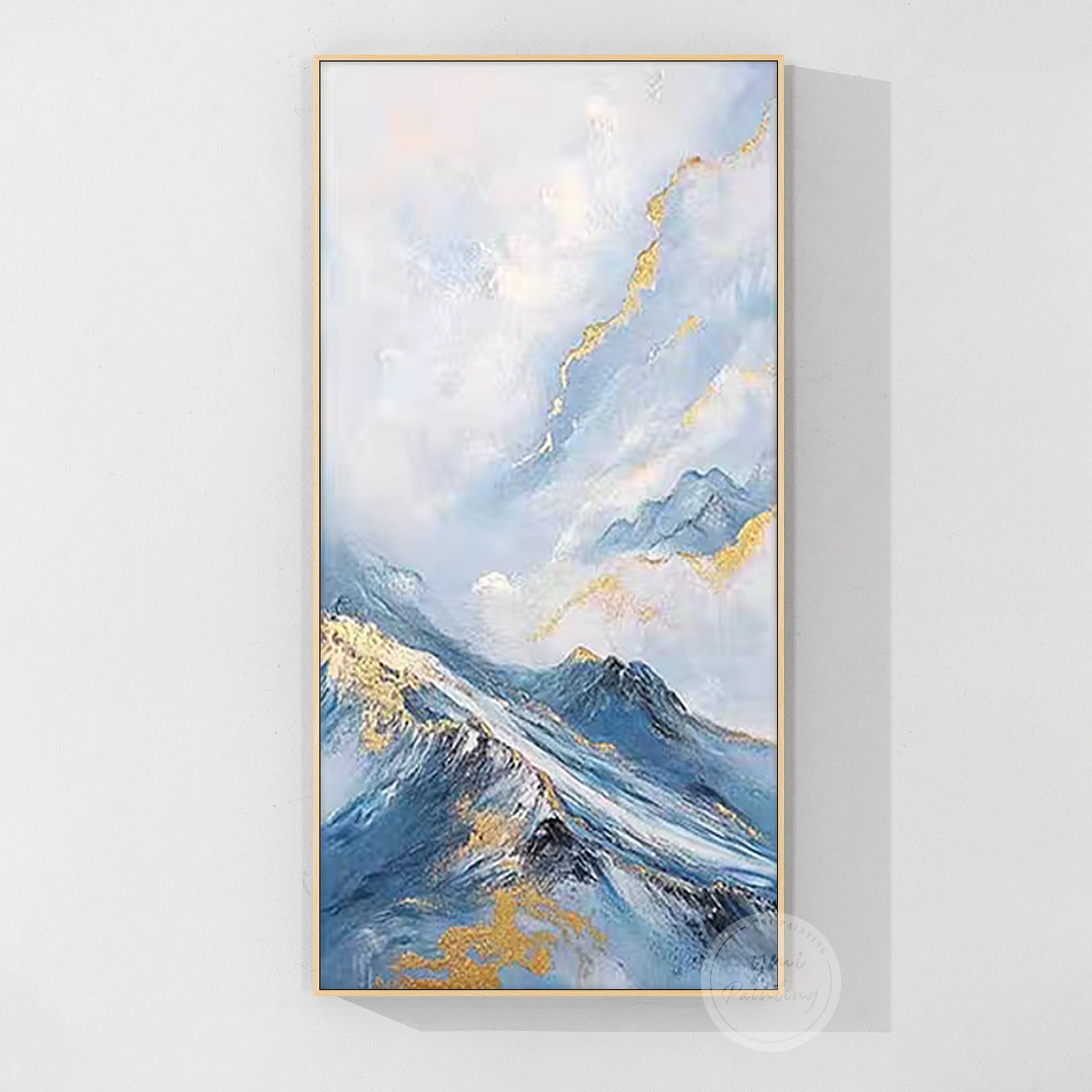
Blue and gold abstract landscape painting hanging above a minimalist sofa, refined housewarming gift
