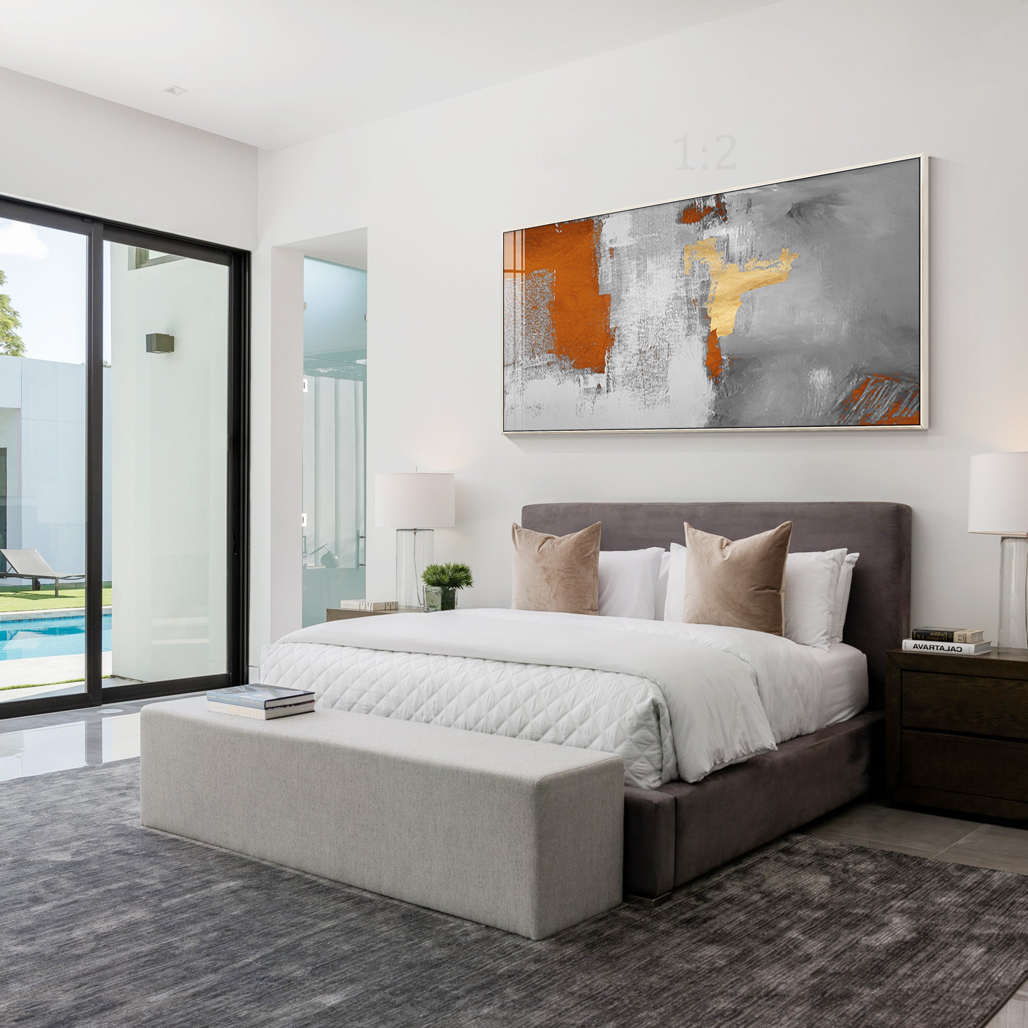 Abstract painting featuring vibrant orange and delicate gold accents hang above the bed head.