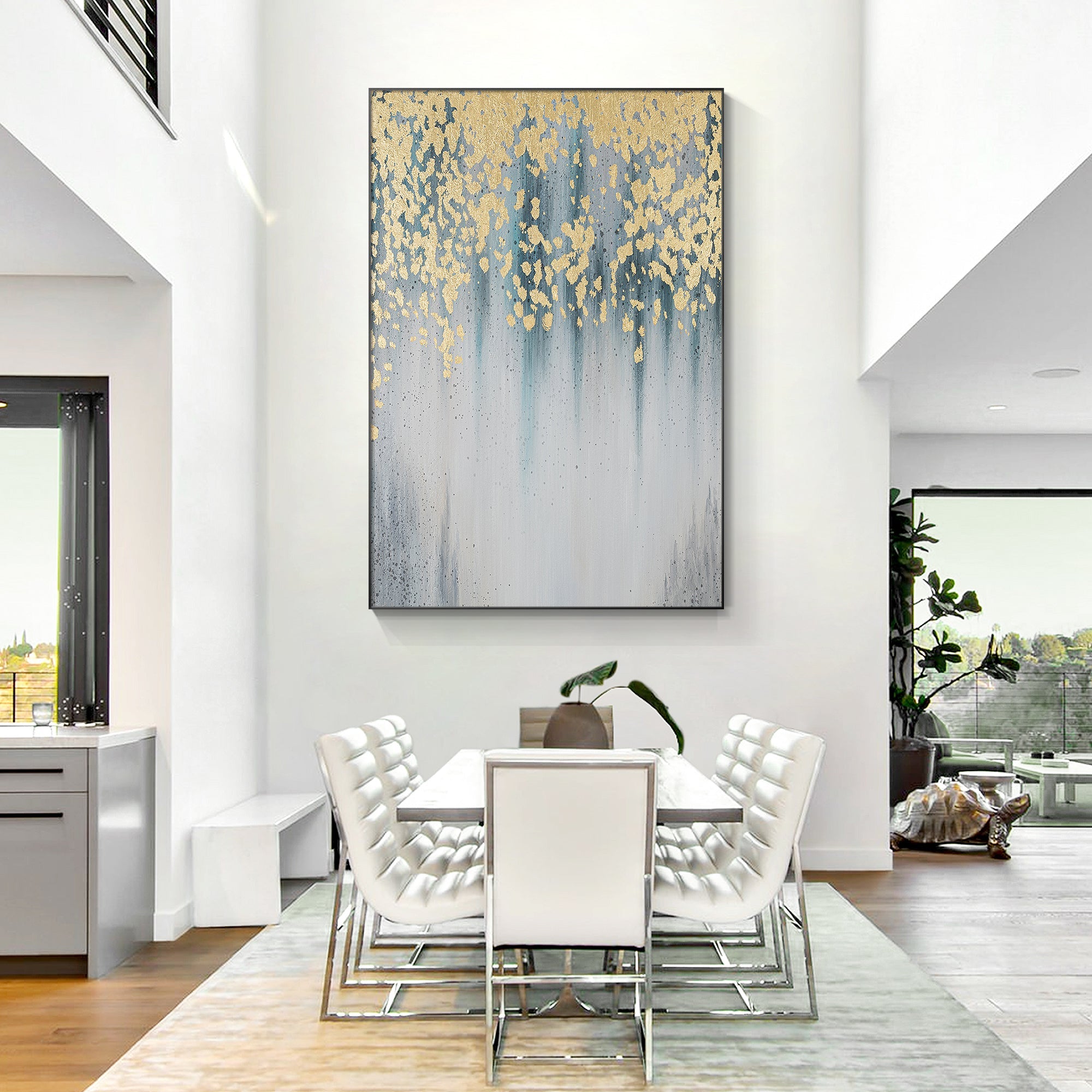 Serene abstract painting featuring gold leaf, water droplets, and blue-gray gradients decorates a living room.