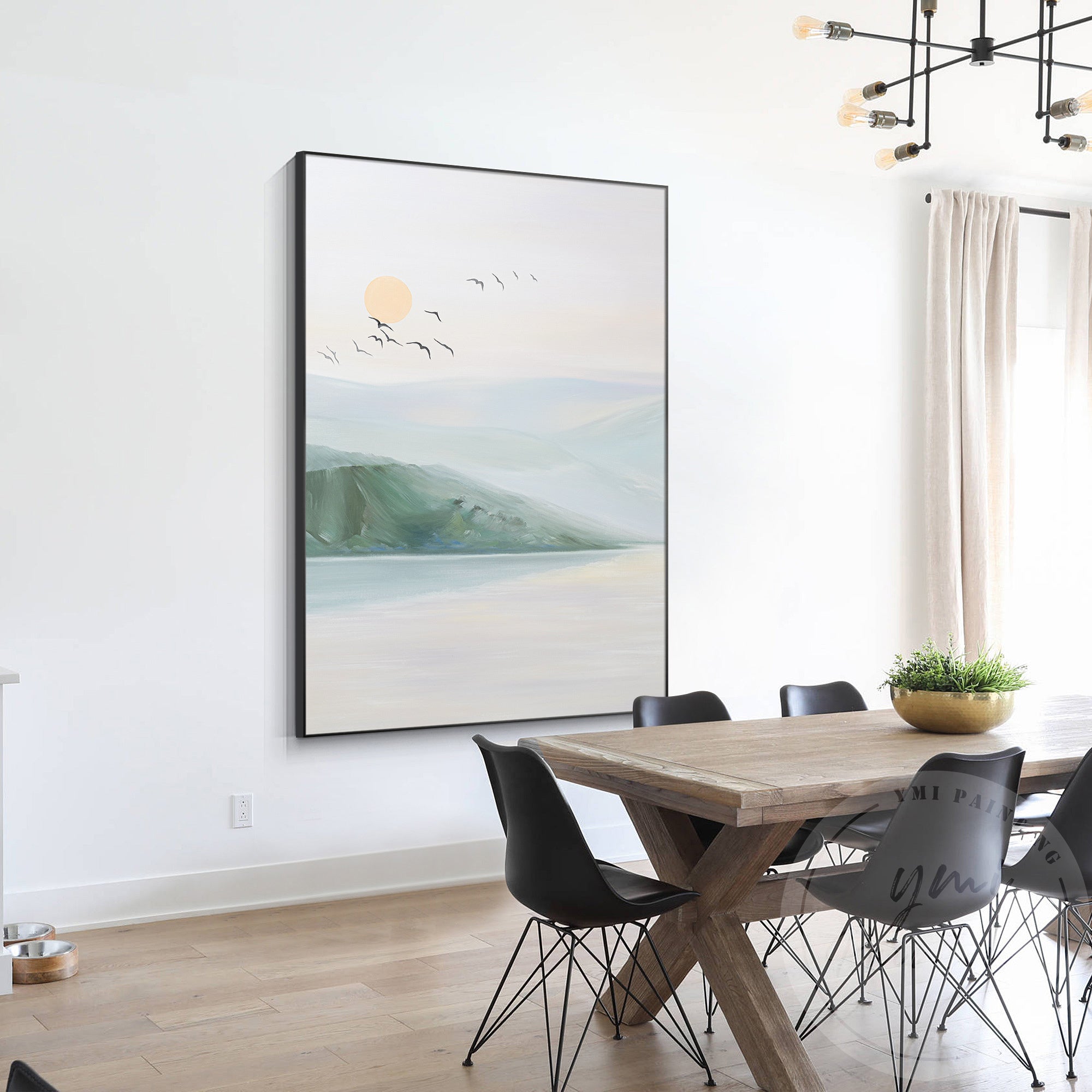 Distant mountains under a peach and pink sunset sky with reflections in the water in a modern meeting room.